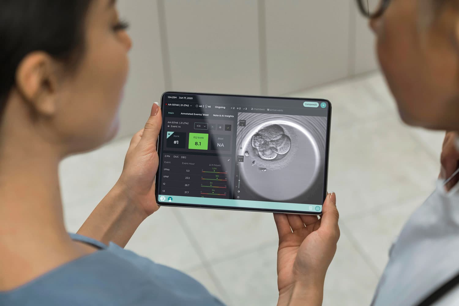 Embryologists reviewing CHLOE timelapse footage on a tablet.
