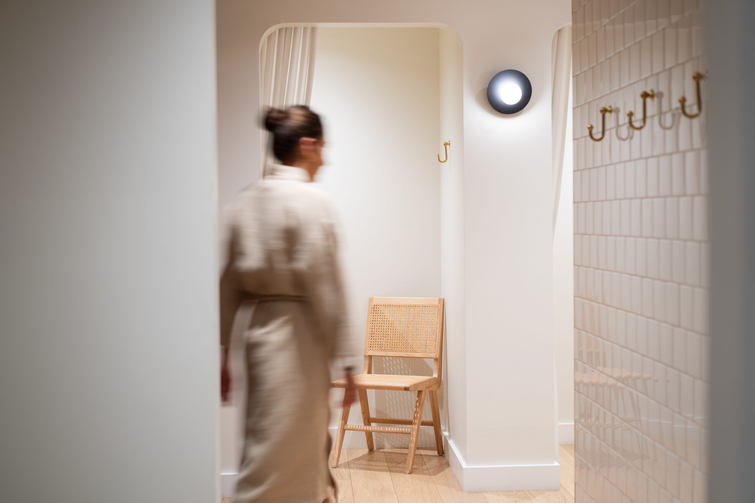 Women walking down hallway in robe.